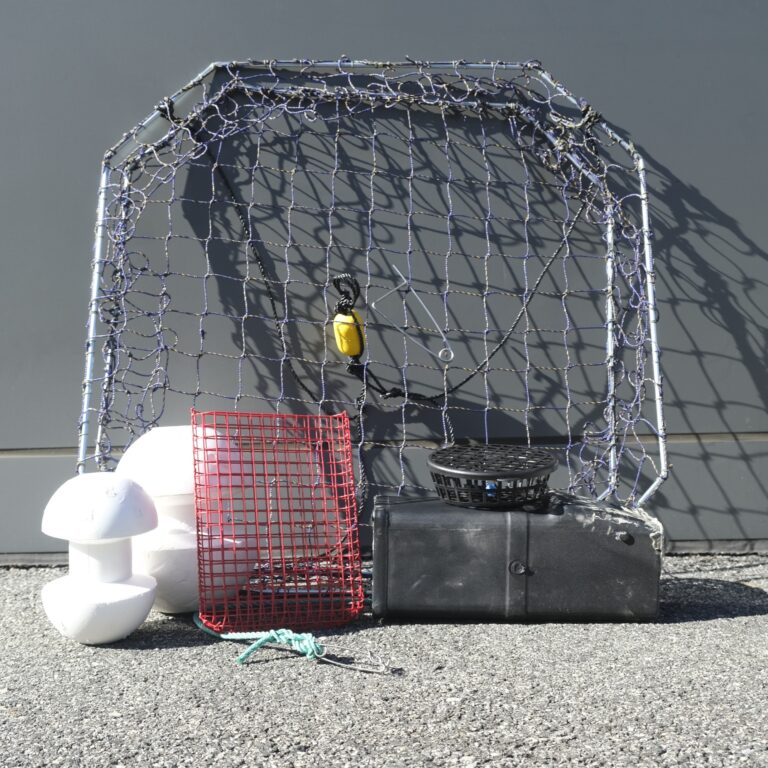 A cage with a red net and some white balls