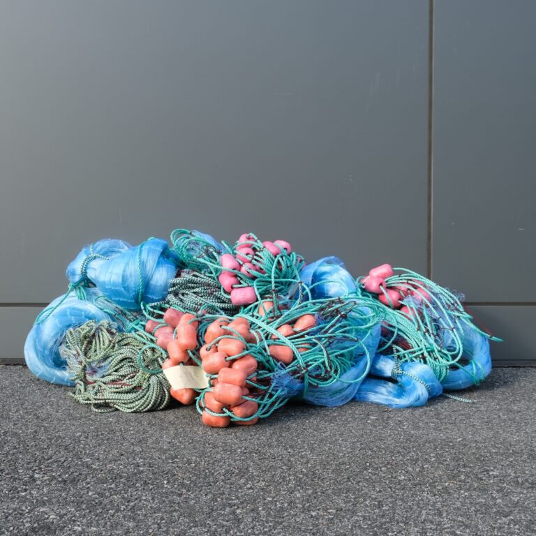 A pile of blue and pink yarn on the ground.