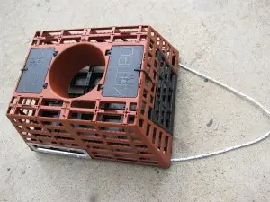 A red plastic cage with a black top.